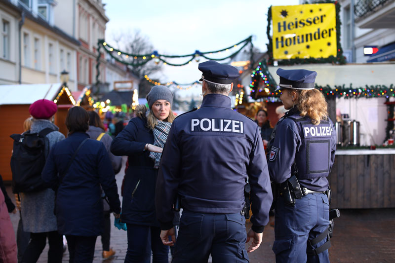 Streifenduo im Gespräch mit einer Frau auf dem Weihnachtsmarkt