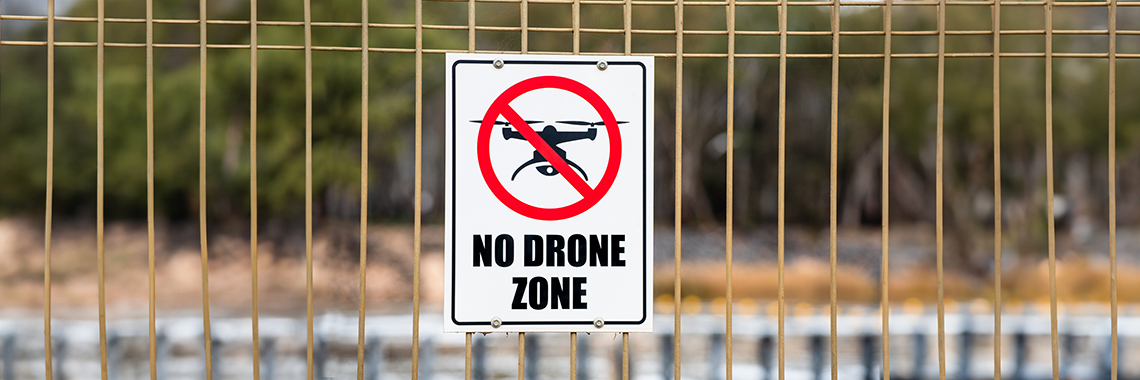 Schild Drohnenverbotszone an einem Zaun 