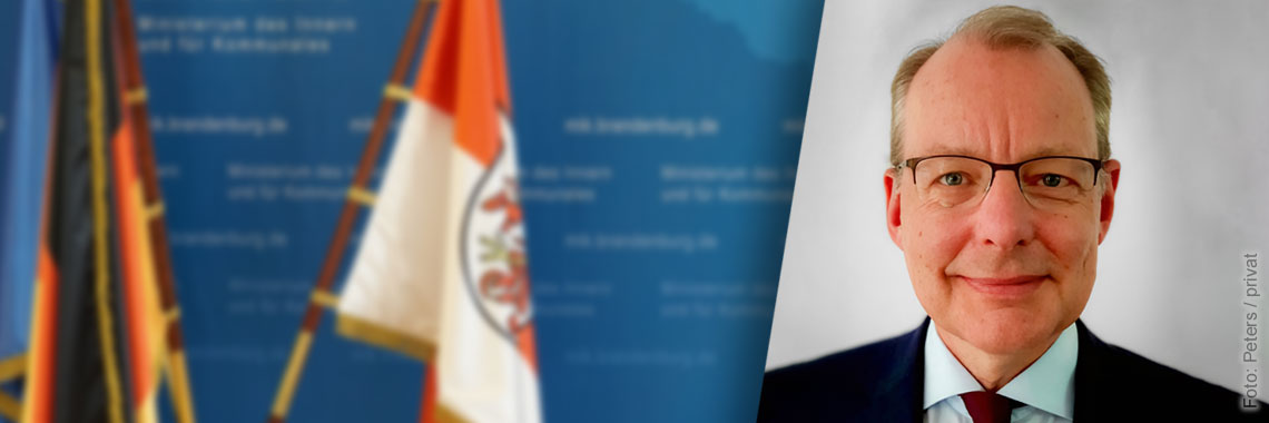 Bild: Blaue Pressewand mit Porträtfoto von Wilfried Peters
