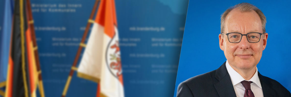 Bild: Blaue Pressewand mit Porträtfoto von Wilfried Peters