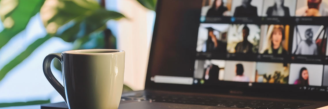 Headerbild VSK Headerbild mit einer Videoschaltkonferenz im Hintergrund und einer Tasse auf einem Schreibtisch im Vordergrund