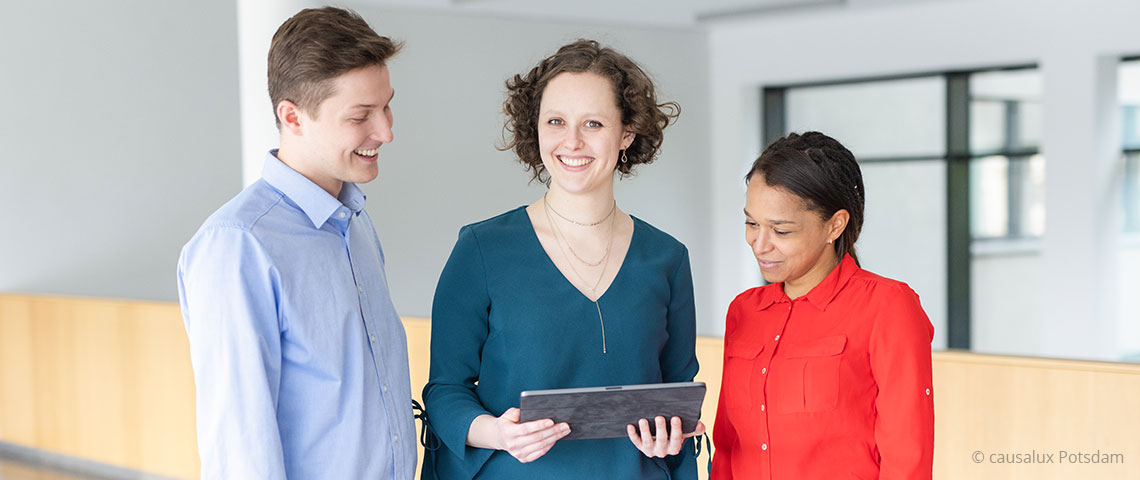 Bild: drei junge Menschen mit Tablet