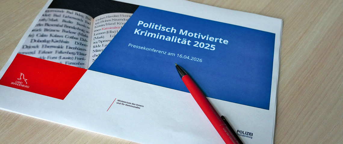 Bild: Grafik: auf einem Tisch liegen die Startfolie der Präsentation zur PK PMK 2025 und ein Kugelschreiber