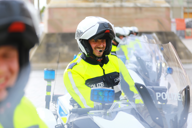 Lachender Polizist sitzend auf dem Motorrad