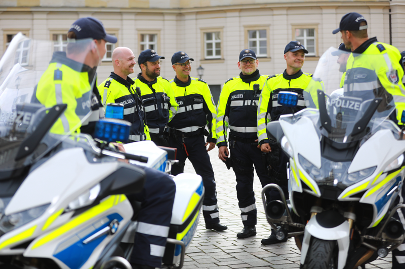 Polizisten im Gespräch stehend neben Motorrädern 