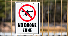 Schild Drohnenverbotszone an einem Zaun 
