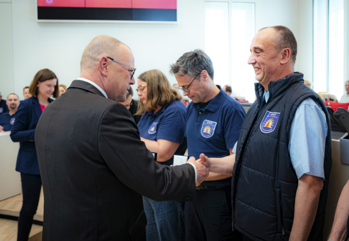 Foto von Minister Stübgen bei der Verleihung des Minister-Coins an einzelne Mitwirkende des ENT