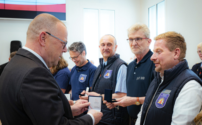 Foto von Minister Stübgen bei der Verleihung des Minister-Coins an einzelne Mitwirkende des ENT