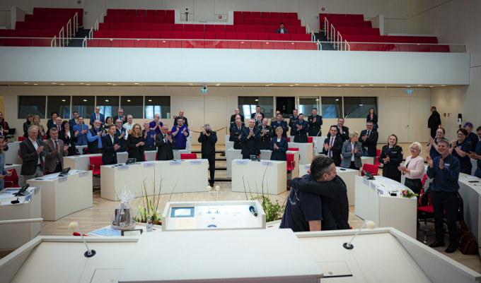 Foto von Herrn Tiedt und Herrn Mehlhorn bei der Ehrung im Plenarsaal mit Gästen im Hintergrund