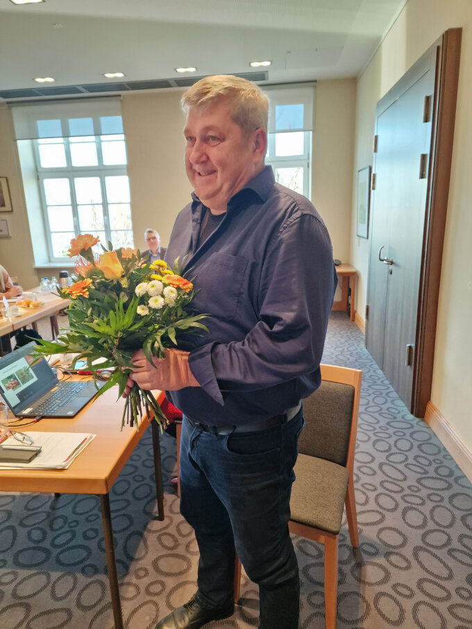 Leiter der Geschäftsstelle des Präventionsrates der Stadt Cottbus/Chóśebuz mit einem Blumenstrauß