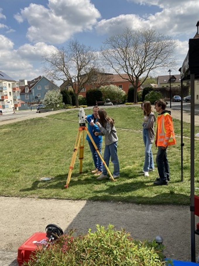 Eine Gruppe von Schülerinnen und Schülern führen Messübungen auf dem Neukirchner Platz durch 